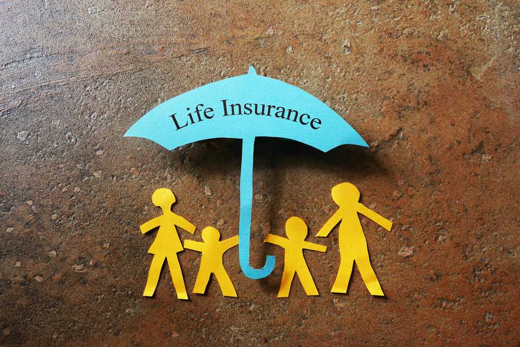 Paper family of four under a Life Insurance paper cutout umbrella